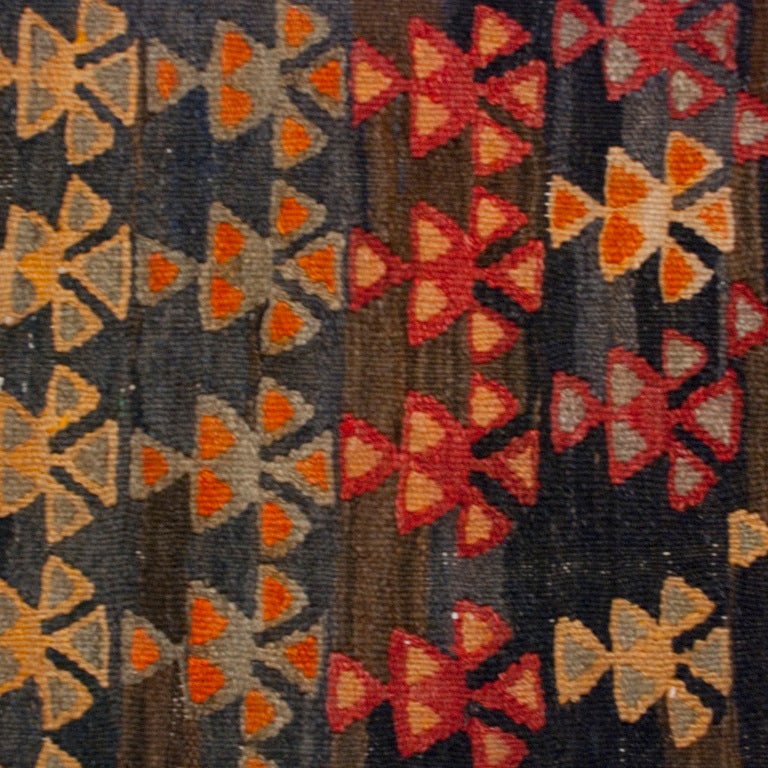 Ein persischer Varamin-Kilim-Teppichläufer aus dem 19. Jahrhundert mit mehrfarbigem, geometrischem Muster auf indigoblauem Hintergrund, umgeben von einer kontrastierenden geometrischen karminroten Bordüre.

Maße: 4'5