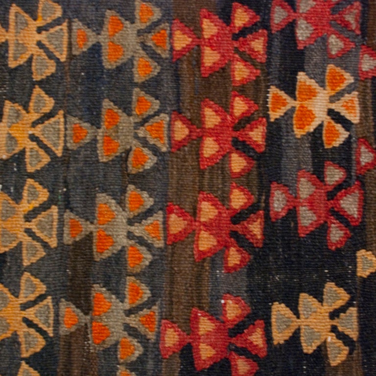 A 19th century Persian Varamin Kilim carpet runner with all-over multicolored geometric pattern in an indigo background surrounded by a contrasting geometric crimson border.

Measures: 4'5