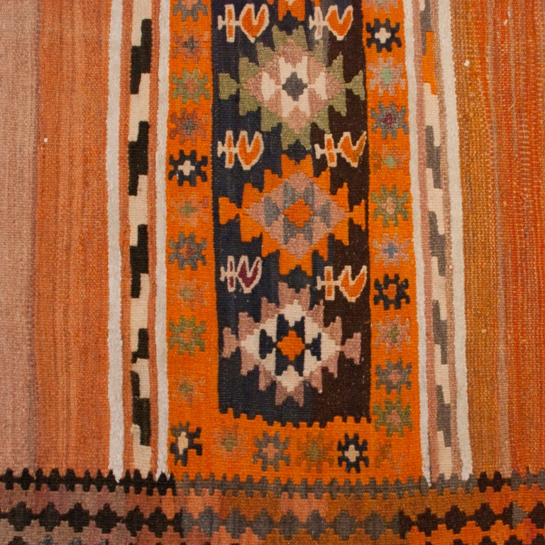 An early 20th century Persian Zarand Kilim carpet with alternating stripe and geometric patterns surrounded by a contrasting geometric border.

Measures: 3'9