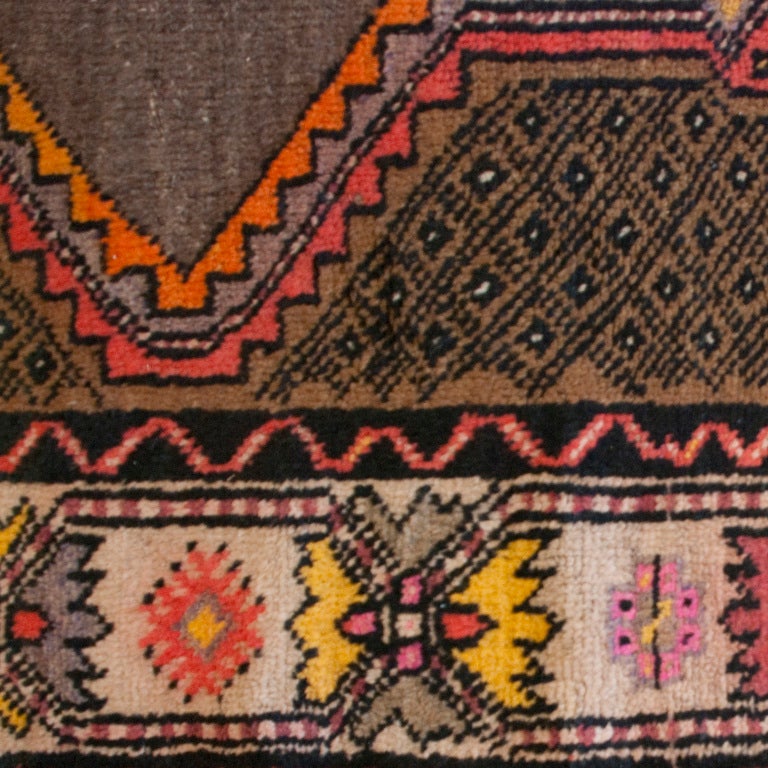 A late 19th century Persian Malayer carpet with multiple diamond medallions on a natural brown background, surrounded by a multicolored contrasting floral border.

Measures: 4'8