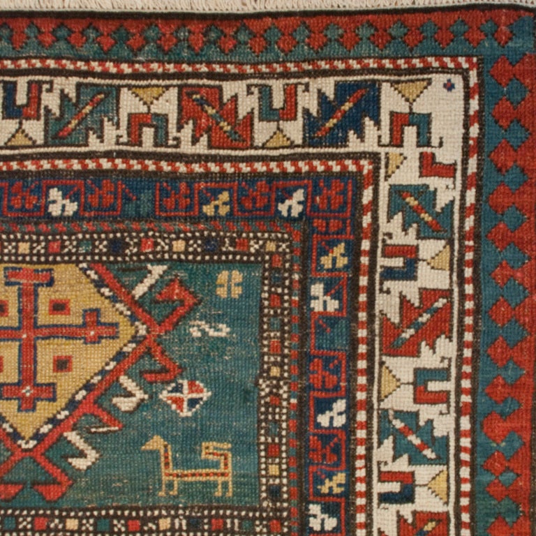 A 19th century Persian Kazak carpet runner with elaborate diamond and geometric shaped medallions amidst a field of more geometric and floral motifs and stylized sheep, surrounded by a contrasting border.

Measures: 3'7