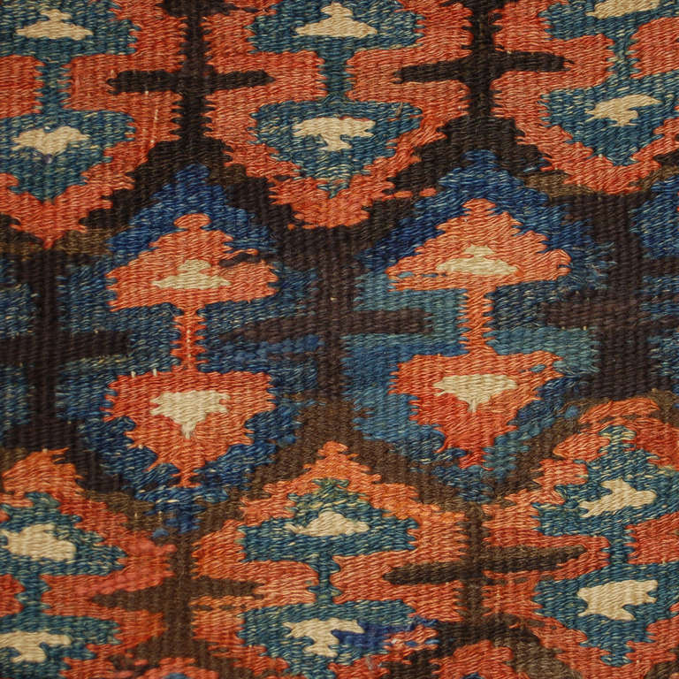 An early 20th century Persian Varamin Kilim runner with exceptional geometric pattern of alternating arrows, surrounded by a complementary border.