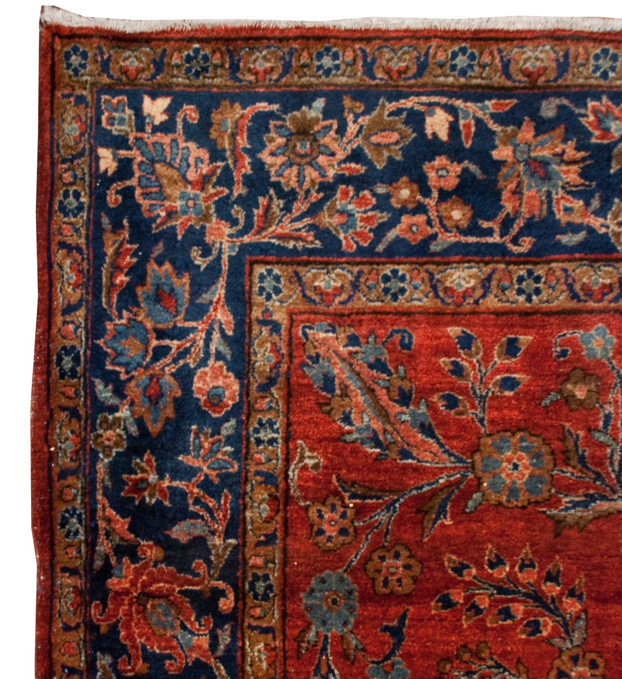 An early 20th century Persian Kashan rug with a beautiful cranberry background with an all-over floral pattern, surrounded by a contrasting indigo floral border.