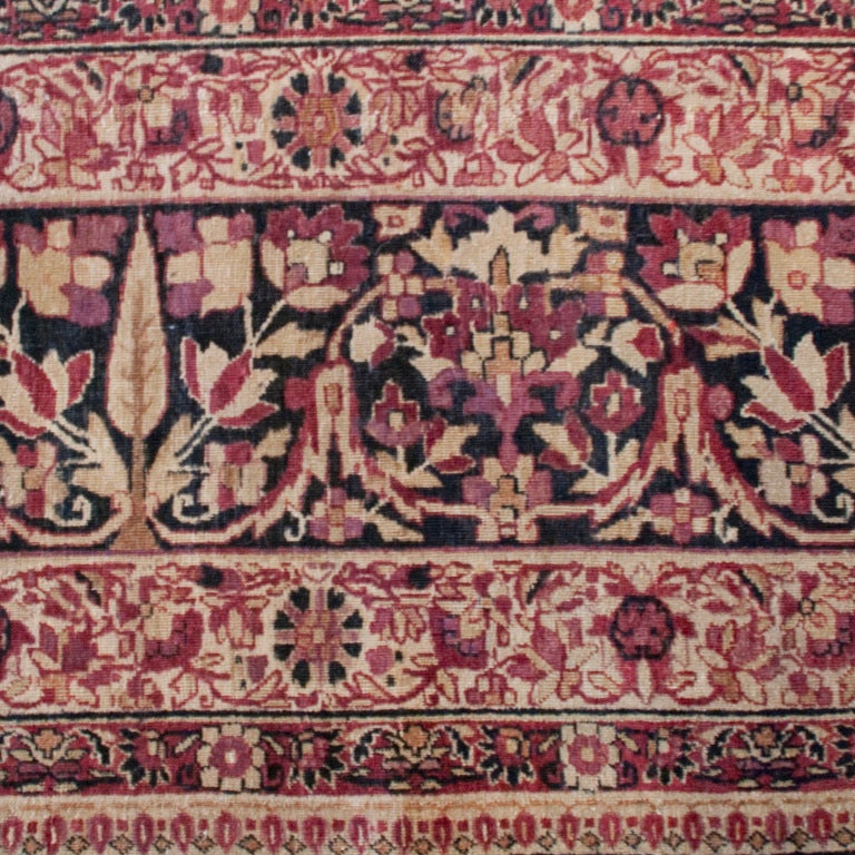 An early 20th century Persian Kirmanshah carpet with central floral medallion on a cranberry background surrounded by a complementary floral border.

Measures: 10'9