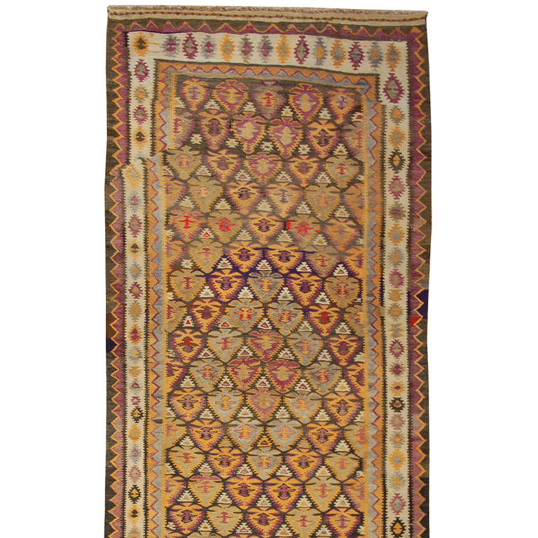 An early 20th century, circa 1920, Persian Qazvin Kilim runner with intricately woven multicolored pattern surrounded by multiple complementary borders.