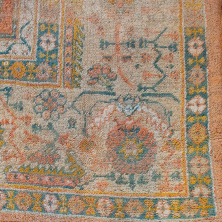 A mid-late 19th century Turkish Oushak carpet with floral and geometric central field on a rust orange background surrounded by a contrasting floral border.

Measures: 13'2
