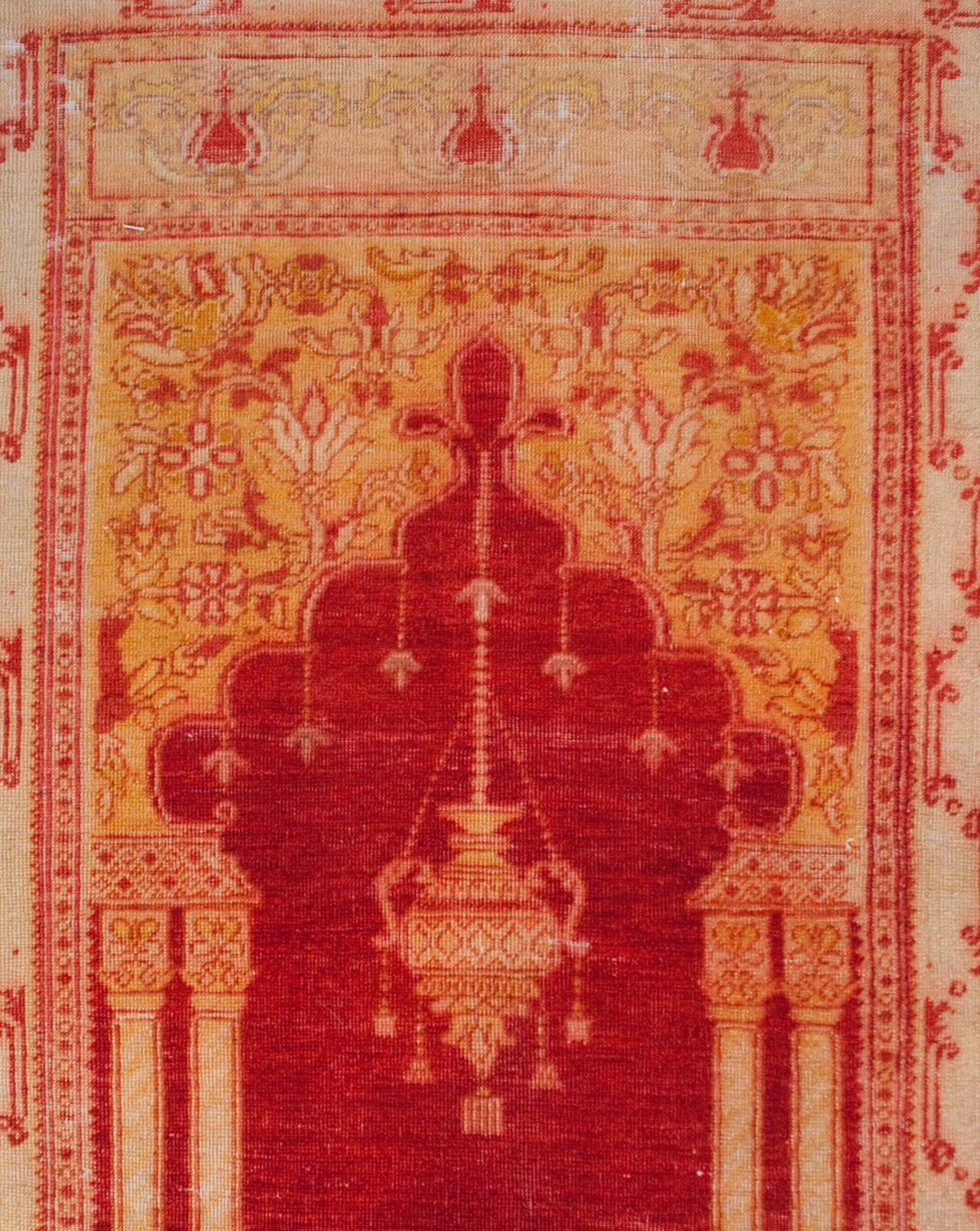 An early 20th century Turkish Oushak prayer rug with a beautifully rendered architectural central field with an Islamic arch and columns, surrounded by a contrasting floral border.
