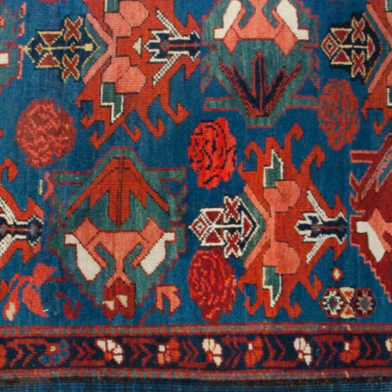 An early 20th century Caucasian carpet with unbelievable crimson, salmon and indigo colors, with a floral and geometric pattern.

Measures: 3'6