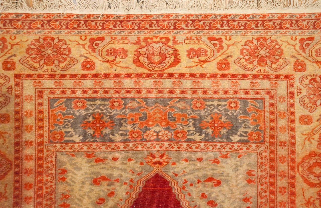 An early 20th century, circa 1900, Turkish Oushak prayer rug with a wonderful rick crimson central field, surrounded by multiple beautiful contrasting floral borders.