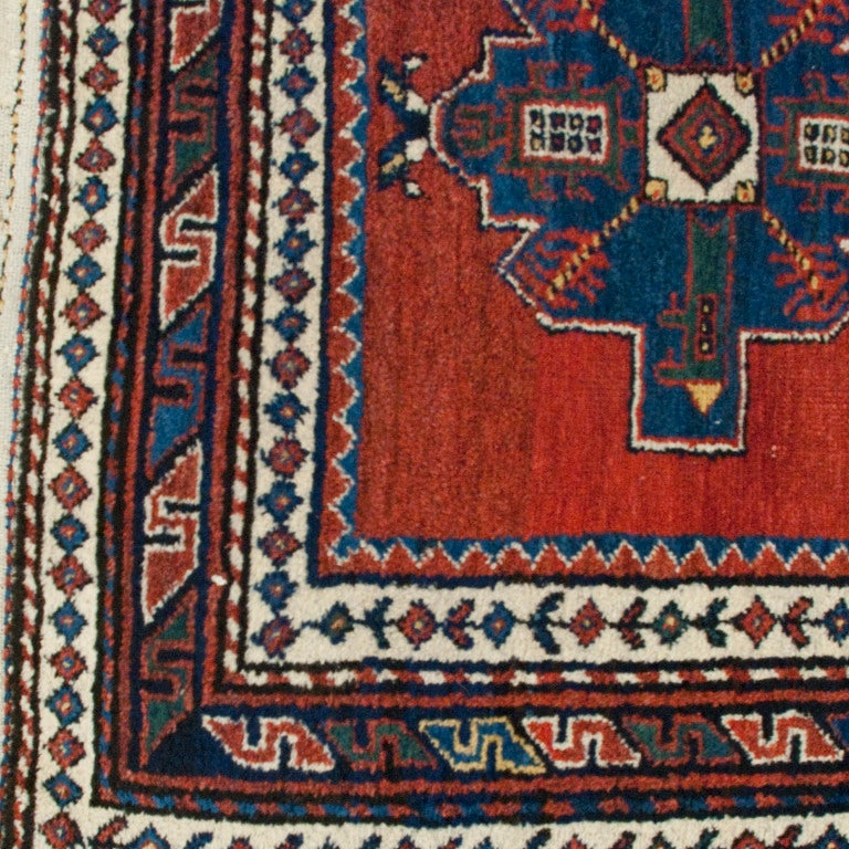 Tapis persan Lori du début du XXe siècle, avec six médaillons sur un fond cramoisi entouré de multiples bordures contrastantes.

Mesures : 3'2
