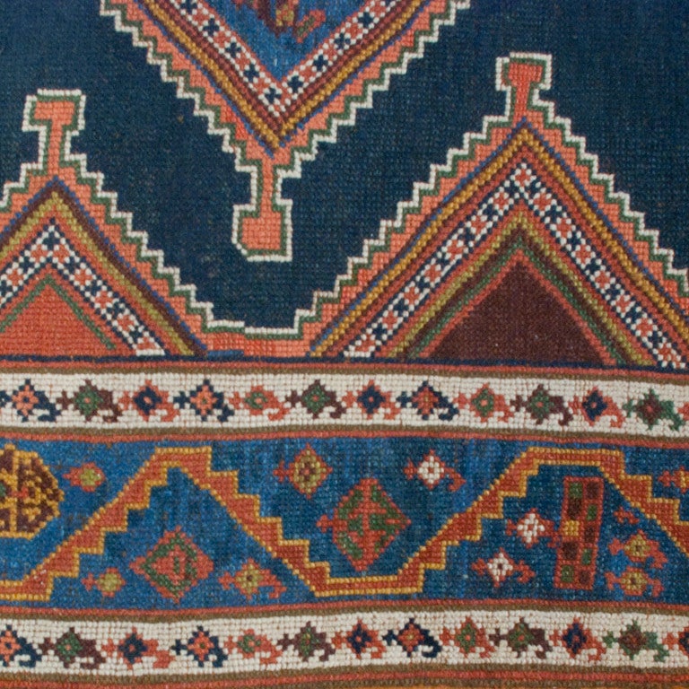 A 19th century Persian Azeri carpet with four diamond medallions on an indigo background surrounded by a complementary floral border.

Measures: 4'6