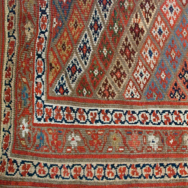 An early 20th century Kurdish carpet with geometric floral pattern surrounded by multiple floral borders.

Measures: 4'7