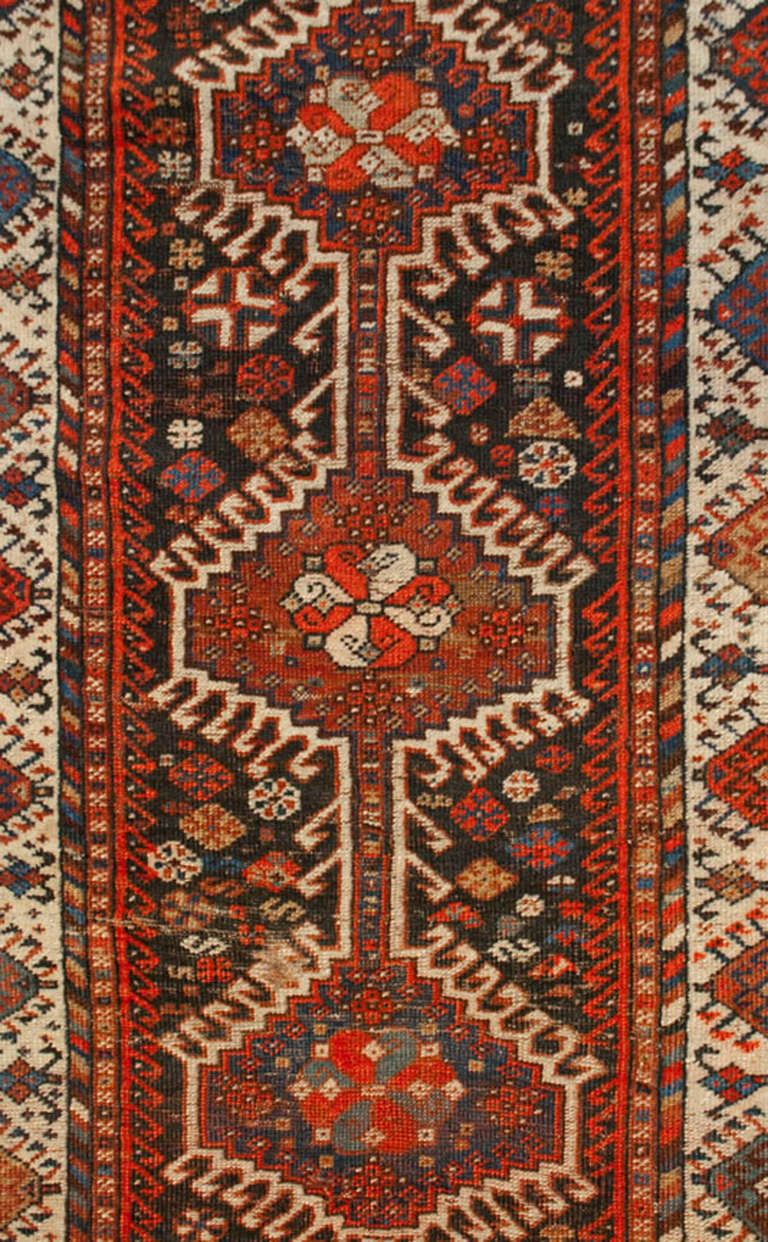 A wonderful early 20th century Persian Qashqai runner with six outstanding central medallions amidst a field of flowers, surrounded by an intricately woven geometric and floral border.