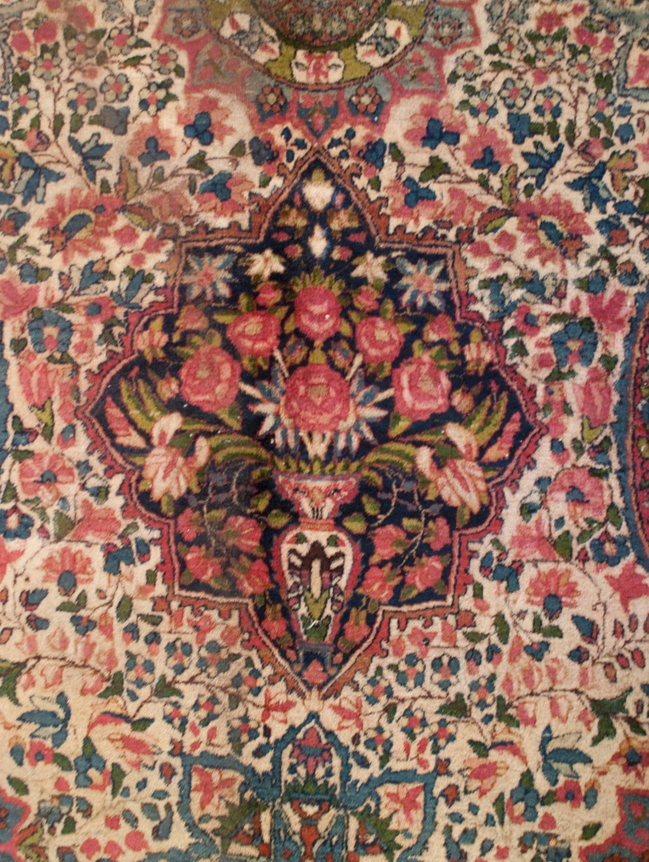 A wonderful early 20th century Persian Kirman rug with multiple floral medallions amidst an intricately woven field of flowers, surrounded by multiple complementary floral borders.