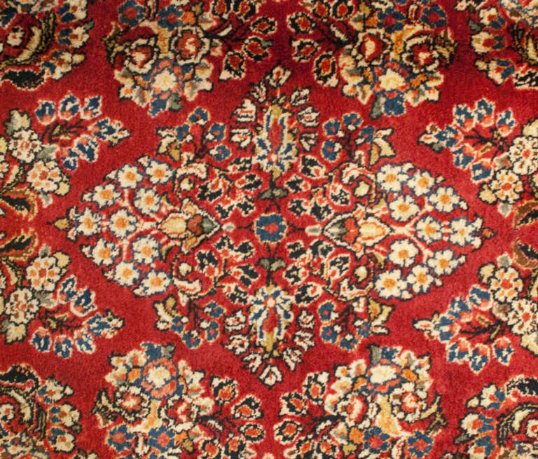 An early 20th century Persian Sarouk runner with wonderful mirrored tree of life pattern on a deep ruby background, surrounded by a complementary floral border.