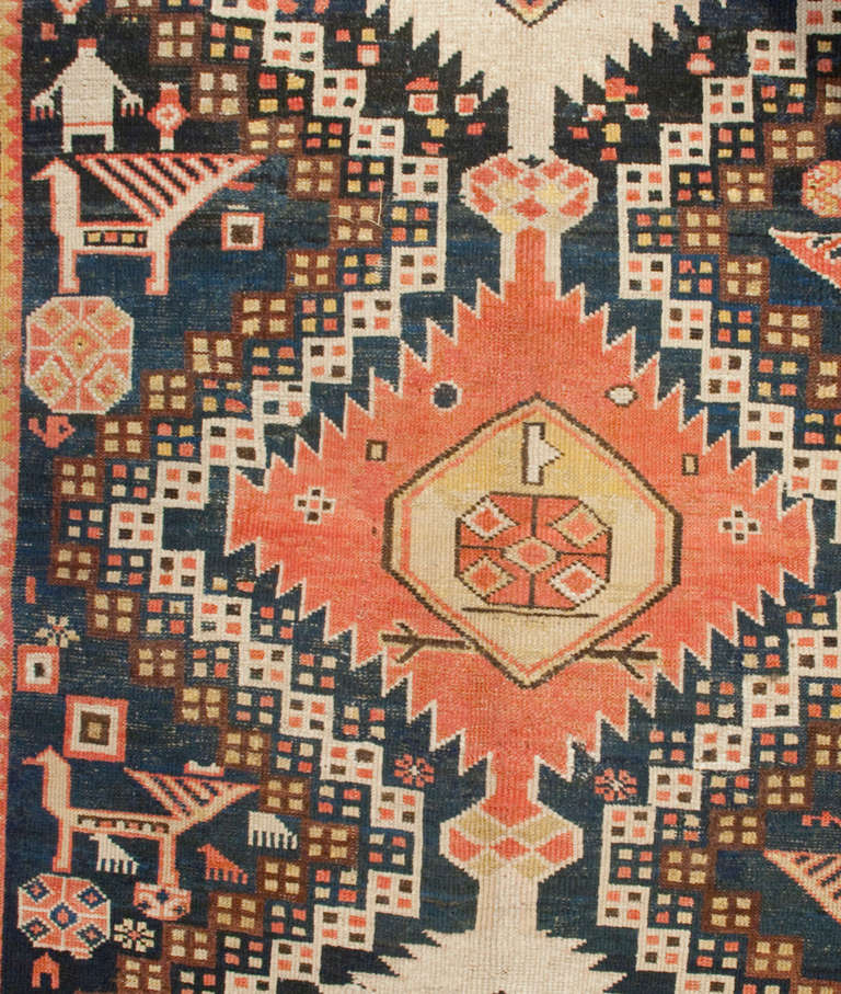 An early 20th century Persian Karabaugh rug with multiple geometric medallions amidst an interesting geometric and animal field, surrounded by a beautiful large-scale floral border.