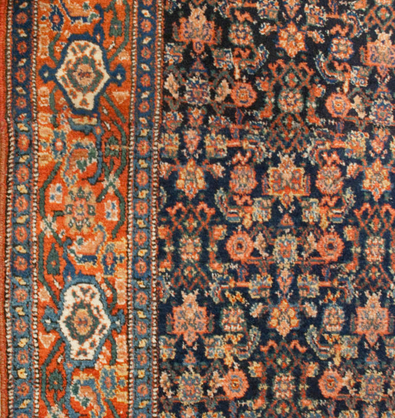 An early 20th century Persian Herati runner with all-over floral pattern on an indigo background, surrounded by a contrasting floral border.