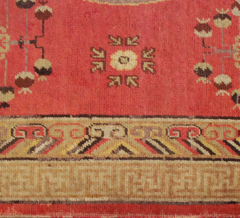 An early 20th century Central Asian Khotan rug with multiple central medallions on a pink background surrounded by multiple contrasting borders.

Keywords: Rug, carpet, textile, quilt, wall hanging, Samarkand, Khotan.