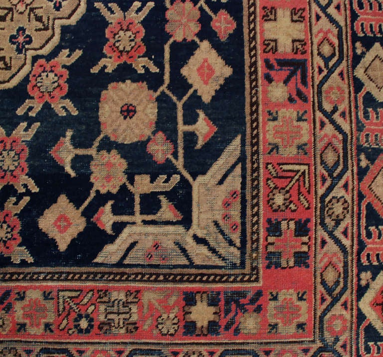 An antique Central Asian Khotan rug with all-over floral diamond pattern amidst a field of flowers and vines, surrounded by multiple contrasting floral borders.

 Measures: 5'10