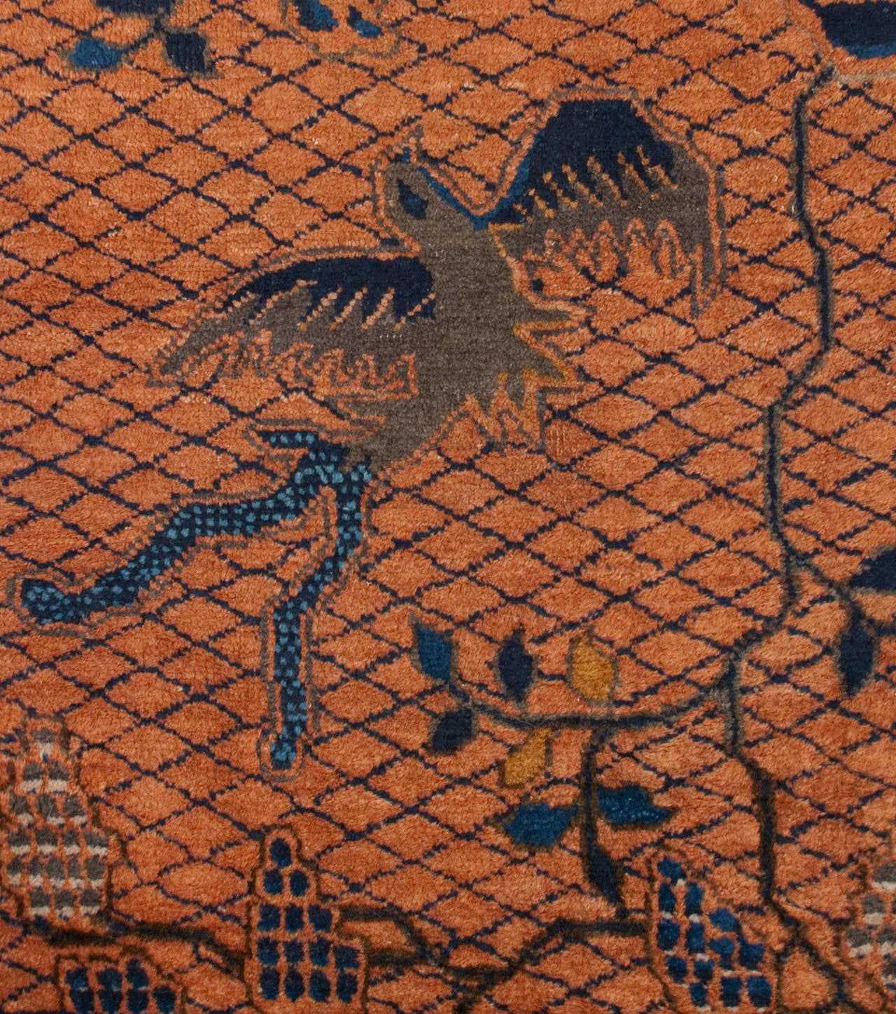 An unusual early 20th century Chinese Peking rug with a beautiful floral and bird design with an indigo border, veiled by an all-over lattice pattern.