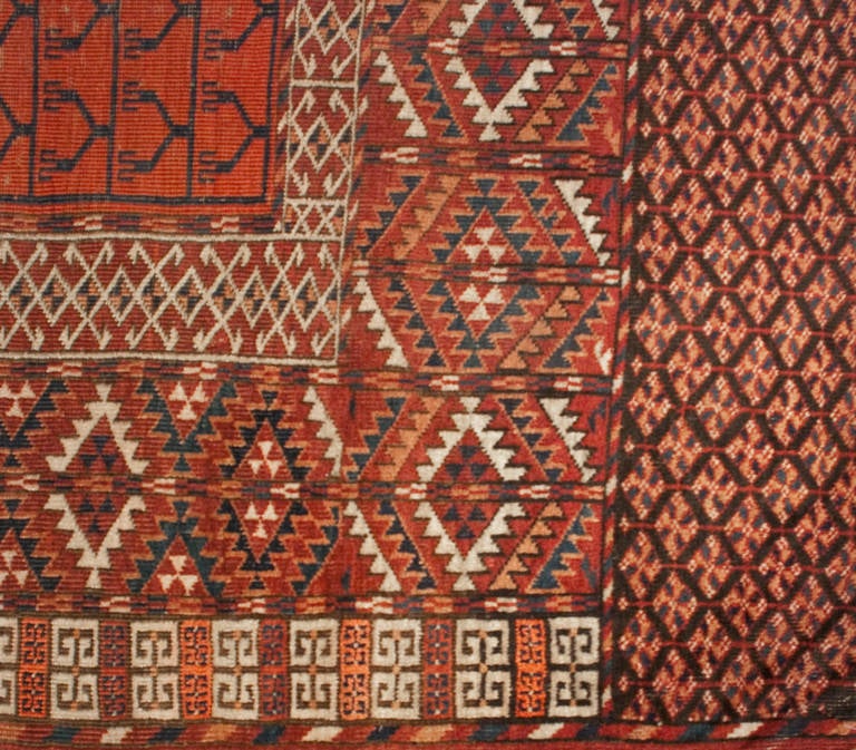 A 19th century Persian Engsi prayer rug with an elaborate mix of floral and geometric patterns in alternating colors of crimson, indigo, orange, and cream, surrounded by a multiple elaborate complementary borders.