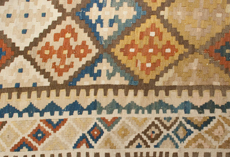 An early 20th century Persian Shiraz Kilim runner with all-over multi-colored diamond and geometric pattern surrounded by a complementary geometric border.