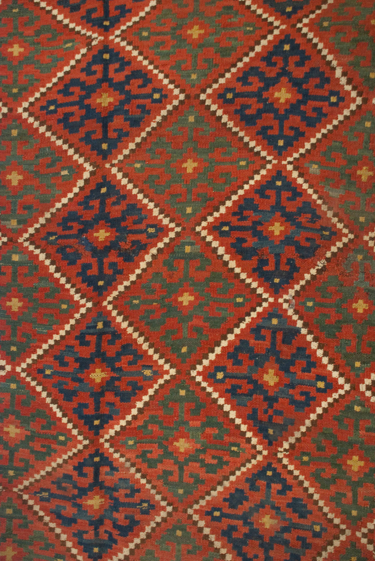 An early 20th century Persian Ersari Kilim rug with a wonderful all-over geometric crimson, emerald, and indigo diamond pattern surrounded by a complementary geometric border.