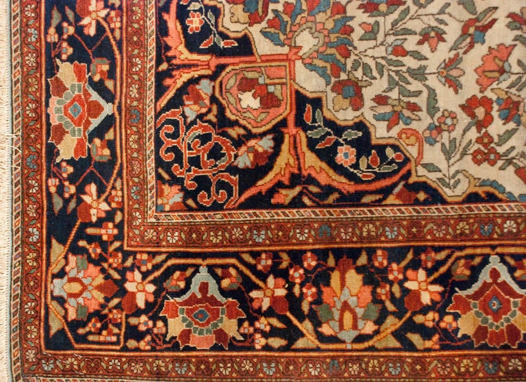 Magnifique tapis persan Sarouk Farahan du 19e siècle, avec un médaillon central de vignes enroulées sur un fond indigo, sur un champ de fleurs multicolores, entouré d'une étonnante bordure florale multicolore complémentaire.