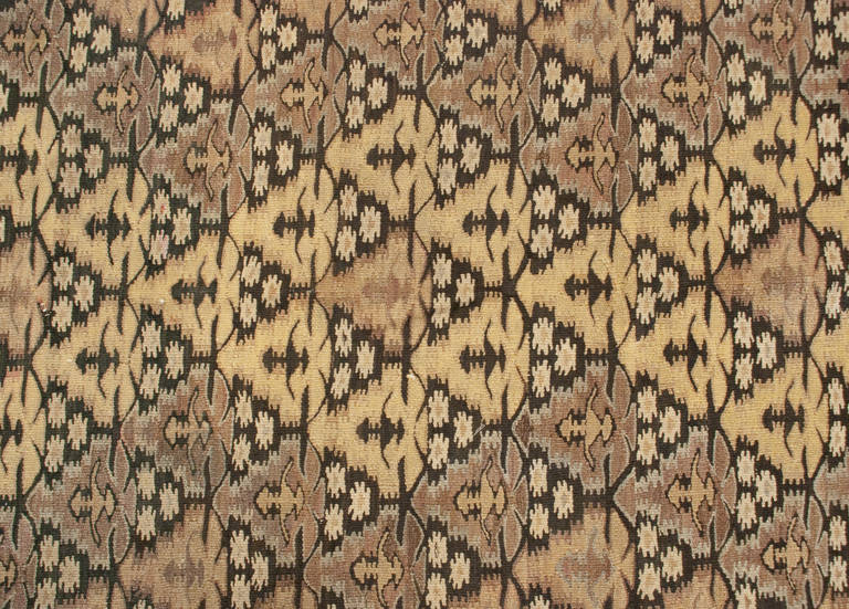 An early 20th century Persian Qazvin Kilim runner with all-over floral pattern woven in natural, undyed, wool, surrounded by multiple complementary borders.