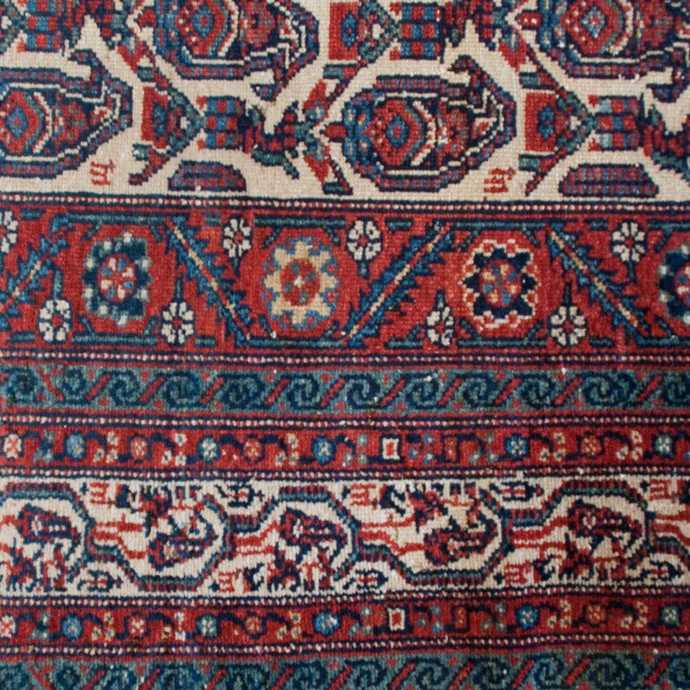 An early 20th century Persian Nahavand carpet with paisley motif field and multiple scrolling vine and floral borders. Measure:4'7