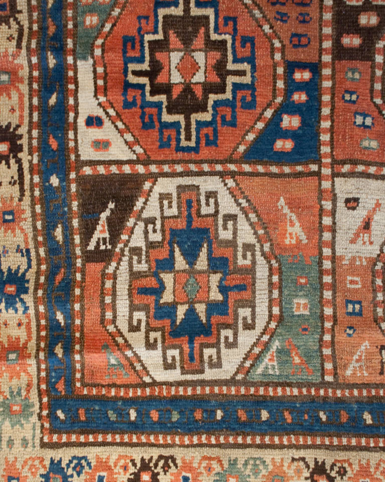A late 19th century Caucasian Moghan rug with eight bold multicolored geometric medallions, surrounded by multiple complementary floral borders.