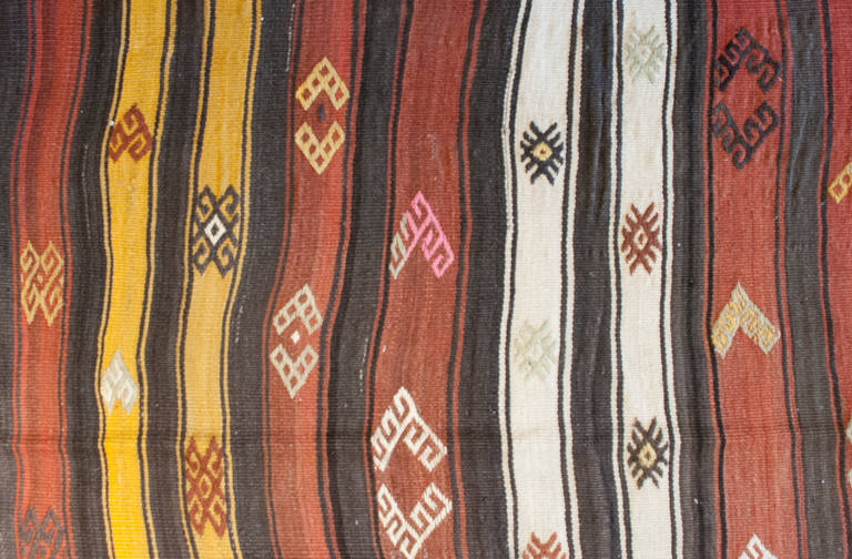 An early 20th century Turkish Erzurum Kilim rug with alternating red, yellow, and white stripes, with multiple geometric patterns.
