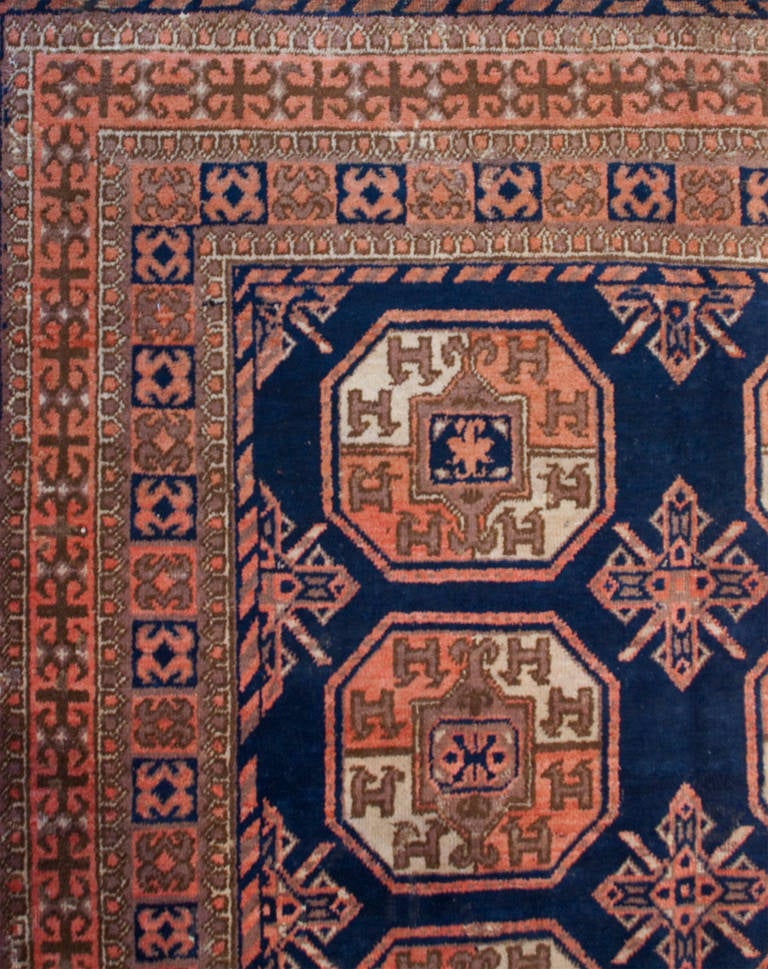 An early 20th century Central Asian Samarkand rug with fourteen octagonal medallions on an indigo background, surrounded by multiple complementary geometric borders.