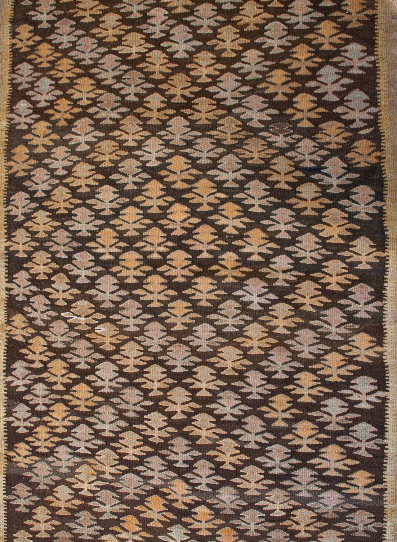 Un runner Qazvin Kilim persiano dell'inizio del XX secolo con un motivo ad albero della vita all-over, circondato da molteplici bordi floreali e geometrici complementari.