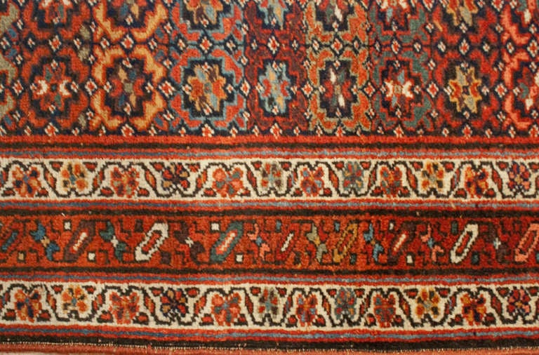 An early 20th century Persian Bidjar runner with alternating floral striped pattern surrounded by multiple complementary floral borders.
