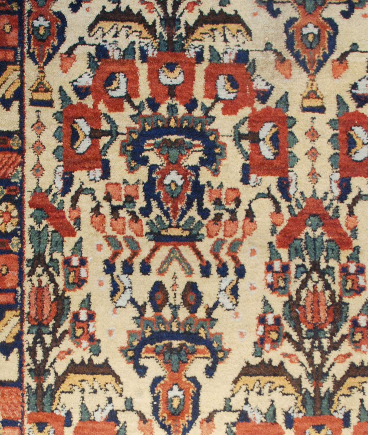 An early 20th century Persian Afshar rug with an all-over pattern of flowers in vases on a natural undyed wool background, surrounded by a complementary floral border.