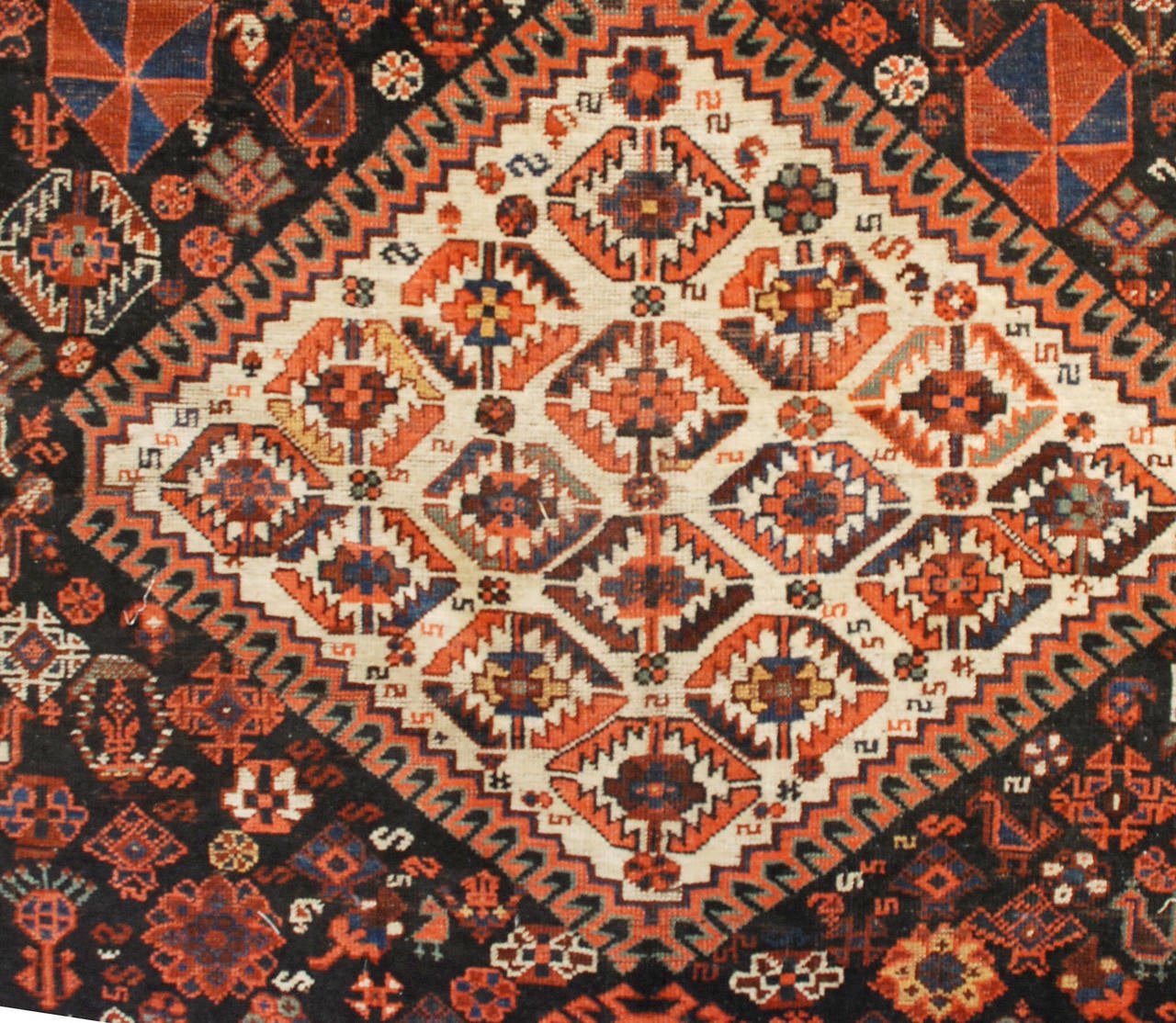 A wonderful late 19th century Gashgai rug with three large diamond medallions amidst an amazing field of flowers, chickens, and goats, surrounded by an intricate system of contrasting floral and geometric borders.