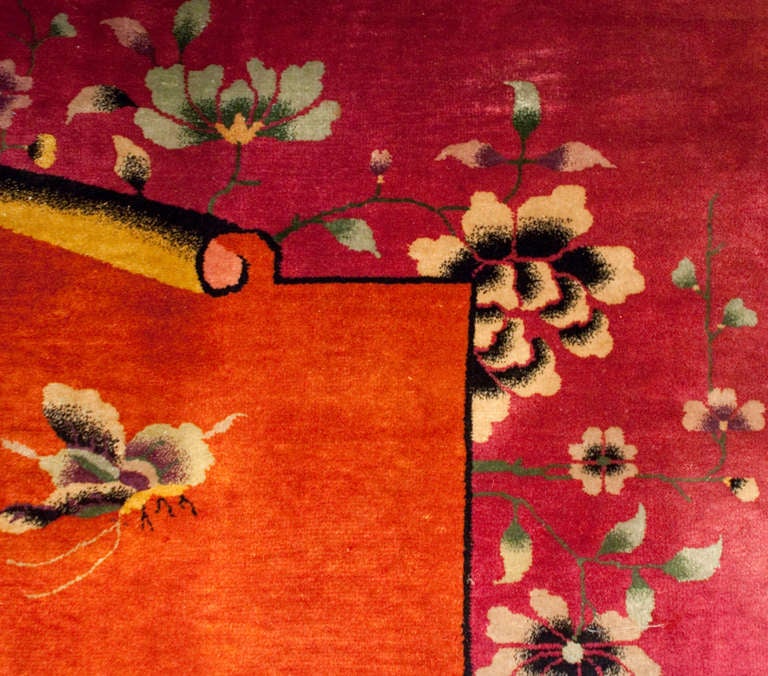 An unusual Chinese Art Deco rug with an interesting composition depicting a   radiant orchid (Pantone's color of the year, 2014) floral border with a brilliant rust colored unfurling scroll with a sweet garden landscape illustration of lotus flowers