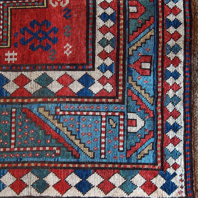 Tappeto persiano Kazak del XIX secolo con tre medaglioni geometrici centrali su sfondo cremisi circondati da un bordo geometrico verde e blu a contrasto.



Misure: 5'2