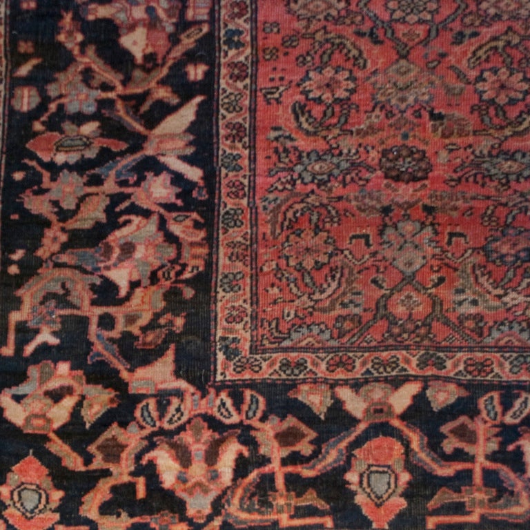 A 19th century Persian Saruk Farahan carpet woven in a Herati pattern with stylized fish motifs and an elaborate scrolling vine and floral border. Measure:6'6