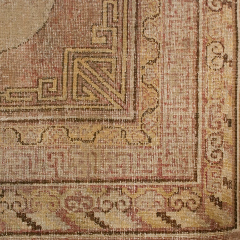 A 18th century Central Asian Samarghand carpet with three large cream colored central medallions on a pale red background surrounded by several contrasting borders.



Measures: 4'10