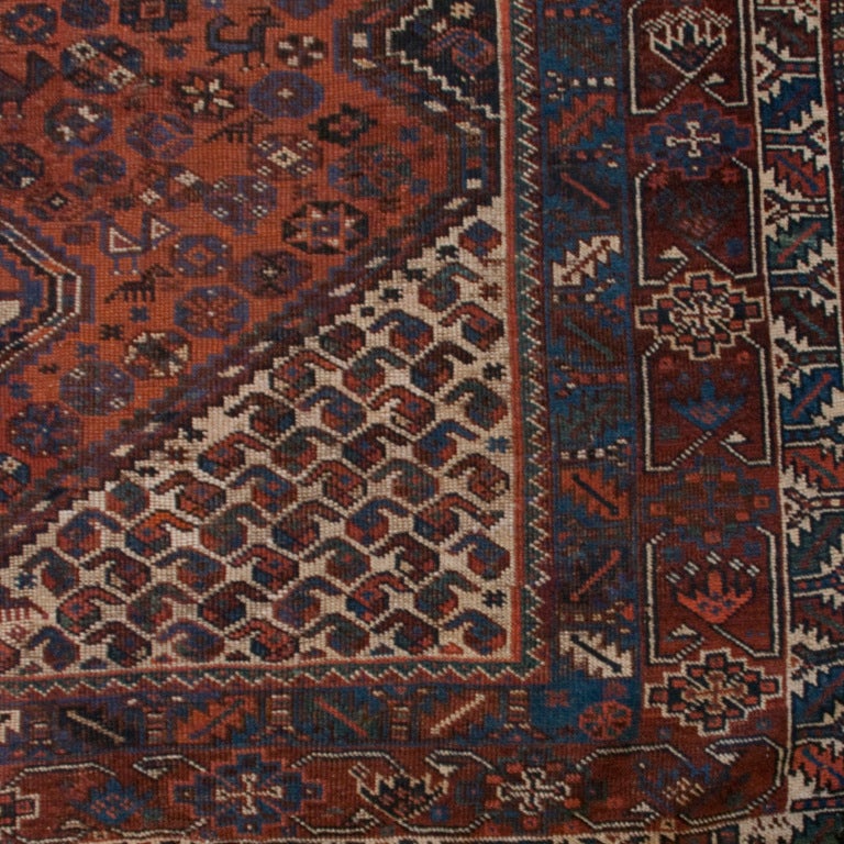 A 19th century Persian Afshar Ghashghaei carpet with four central diamond medallions on a crimson field of floral, animal, and geometric shapes, surrounded by multiple contrasting borders.



Measures: 9'2