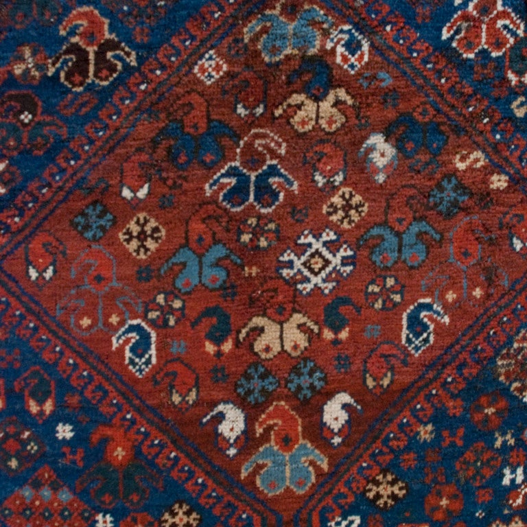 An early 20th century Ghashghaei carpet with three large central diamond medallions surrounded by myriad floral, animal and geometric patterns on an indigo background, surrounded by several contrasting borders.



Measures: 6'9