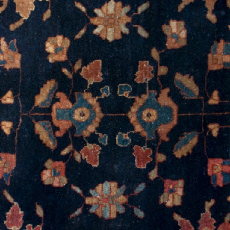 A 19th century Persian Saruk Mahajeran carpet with floral patterns on an indigo background, surrounded by a contrasting border. Measure:6'5