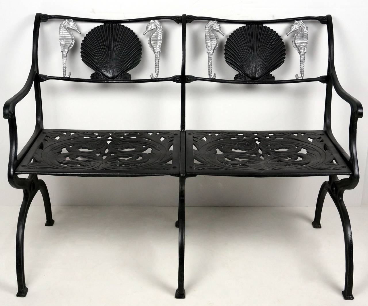 This garden settee with its seahorse and shell motif was designed and created by Molla in the 1950s. It is fabricated in cast-aluminium and is painted in a flat black and metallic silver.

There are also a pair of arm chairs available in the same