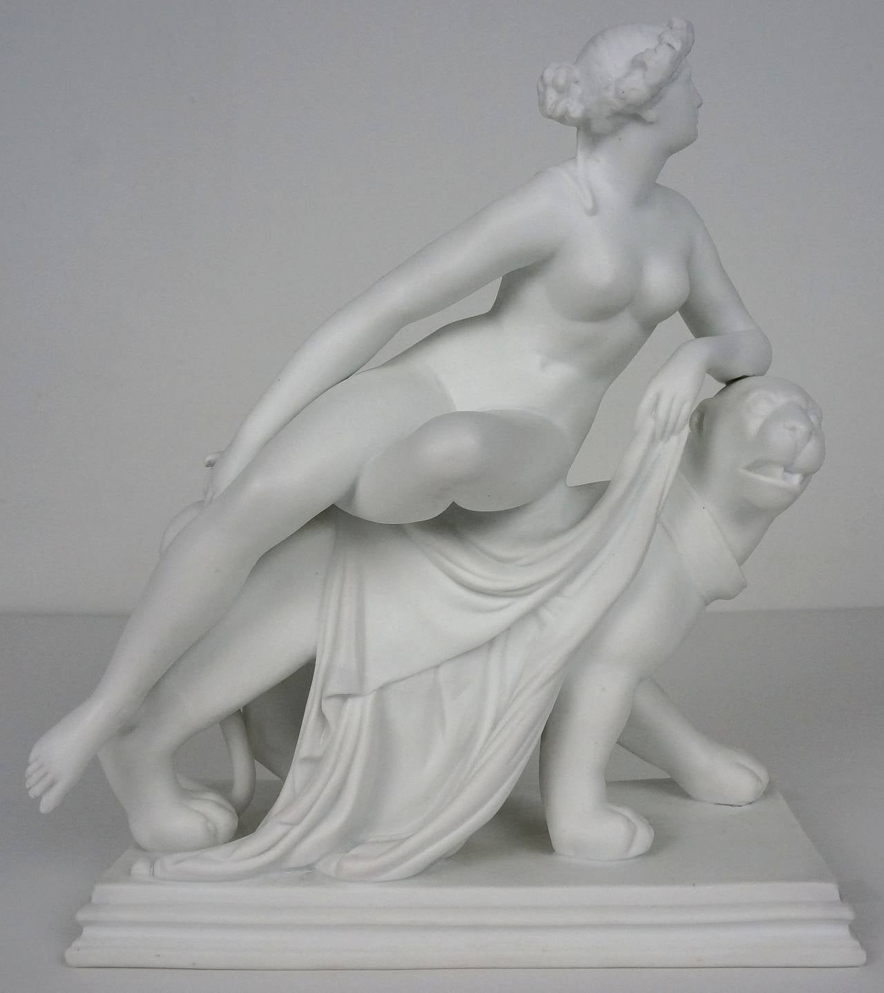 Minton Group 'ARIADNE on a PANTHER'
A Parian-ware figure of Ariadne reclining nude on the back of a stylized panther, moving towards the right; she wears an acanthus wreath on her head, her left leg tucked beneath her right, holding drapery in her