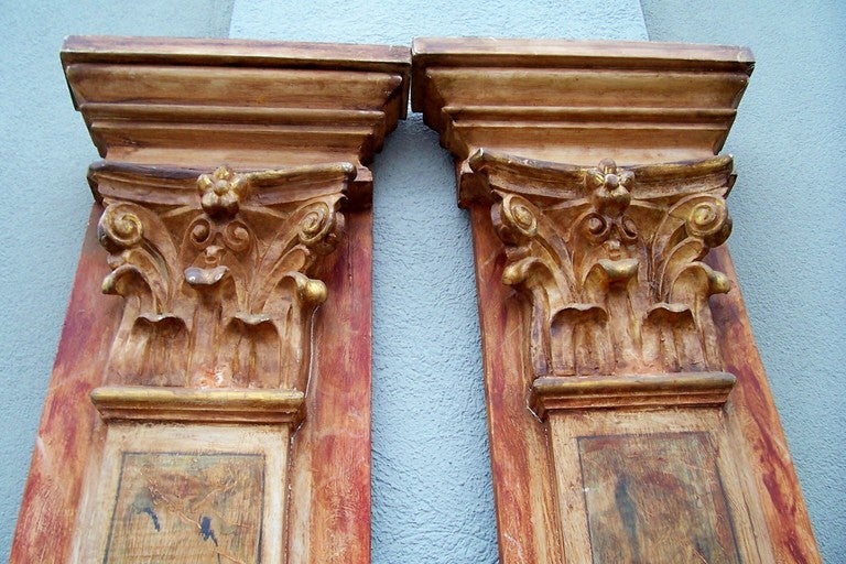 Pair of pilaster column  panels with Corinthian capitals and faux marble finishes. The capitals with glazing and a gilt wash for highlights. Light weight (probably pine or fruitwood) for shipping and wall attachment.. 
Great architectural addition