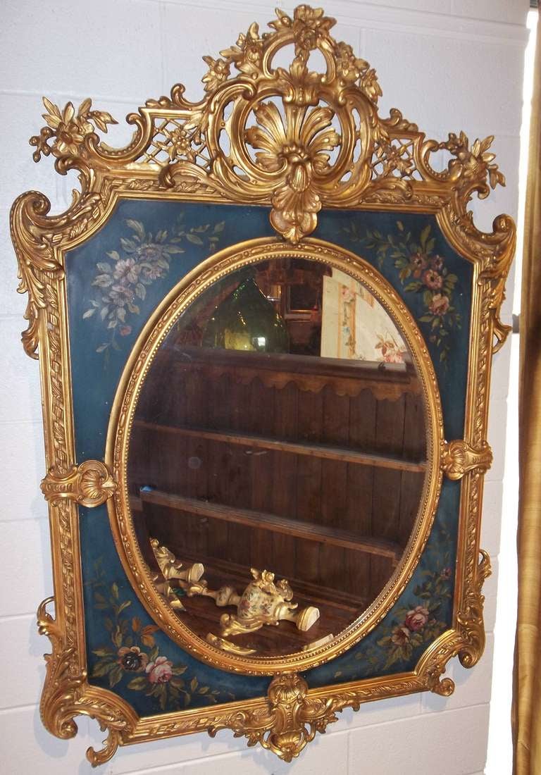 Oval beveled mirror plate surrounded by painted, and carved gilt decorated frame in the Beaux Arts style ( early 20th century adaptation Louis XVI ). Combination of matte and water gilding. Measures: 62 x 41 x 3 inches .

Excellent condition given
