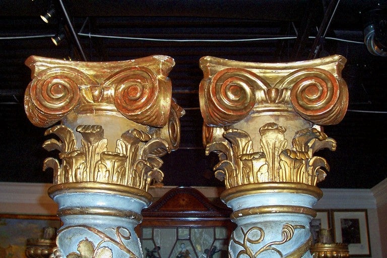 Pair of Baroque styled carved and gilt decorated painted Solomonic (after King Solomon's temple ) columns . Hand chiseled and carved shafts with a pale blue-grey paint on later faux terra cotta and gilt glazed bases . Overall height 85.5 inches tall