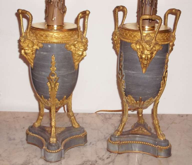 Crisp fine casting and chasing to the , Each lamp with three handles ending in masks of human form with ram horns and grapes .
13 inches tall to urn handles .